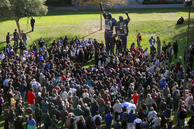 San Jose State University students gather around the 1968 Olympic statue of John Carlos and Tommie Smith while protesting a reported racial hazing of an African-American freshman last month on Nov. 21, in San Jose, Calif. (AP Photo/San Jose Mercury News, Karl Mondon) 
