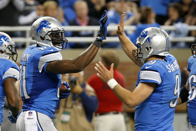 Detroit Lions wide receiver Calvin Johnson, left, celebrates his 2-yard touchdown reception with quarterback Matthew Stafford (9) during the first half of an NFL football game in Detroit, Sunday, Oct. 27, 2013. (AP Photo/Duane Burleson)