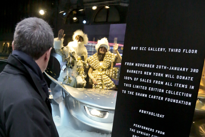 Live models in a Christmas window called "Sleigh Ride" at Barneys New York, wave to a pedestrian on Nov. 20, in New York. The window is one of four holiday windows promoting a charitable collaboration between Barneys and Shawn "Jay-Z" Carter. (AP Photo/Bebeto Matthews)