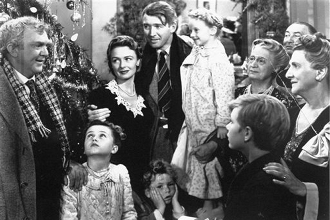 In this 1946 file photo originally provided by RKO Pictures Inc., legendary actor James Stewart as George Bailey, center, is reunited with his wife played by actress Donna Reed, third from left, and family during the last scene of Frank Capra's "It's A Wonderful Life." (AP Photo/RKO Pictures Inc.)