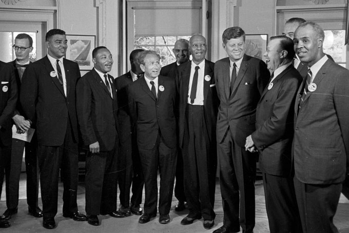 In this Aug. 28, 1963 file photo, President Kennedy stands with a group of leaders of the March on Washington at the White House in Washington. Immediately after the march, they discussed civil rights legislation that was finally inching through Congress. The leaders pressed Kennedy to strengthen the legislation; the president listed many obstacles. Some believe Kennedy preferred to wait until after the 1964 election to push the issue. Yet in his public speeches, he spoke more and more about justice for all. From second left are Whitney Young, National Urban League; Dr. Martin Luther King, Christian Leadership Conference; John Lewis, Student Non-violent Coordinating Committee, partially obscured; Rabbi Joachim Prinz, American Jewish Congress; Dr. Eugene P. Donnaly, National Council of Churches; A. Philip Randolph, AFL-CIO vice president; Kennedy; Walter Reuther, United Auto Workers; Vice President Lyndon B. Johnson, partially obscured, and Roy Wilkins, NAACP. (AP Photo/File)