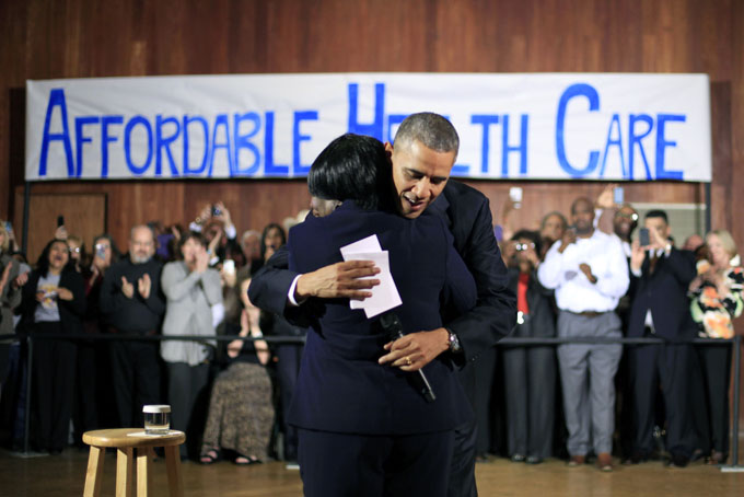 President Barack Obama hugs Edna Pemberton, who introduced him, before speaking with volunteers who helped people enroll through the HealthCare.gov site at Temple Emanu-El Wednesday, Nov. 6, 2013, in Dallas. (AP Photo/Pablo Martinez Monsivais)