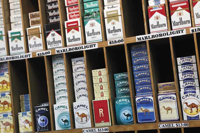 Cigarette packs are displayed at a convenience store in New York. On Oct. 30, 2013, law makers in New York City voted to raise the cigarette-buying age from 18 to 21. (AP Photo/Mark Lennihan, File)