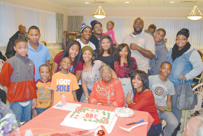A MILESTONE CELEBRATION--Loved ones gathered together to celebrate the 100th birthday of Carrie Baldwin on Dec. 7 in Duquesne, Pa. Pictured above, is Baldwin, center, with family and friends. (Photo by Christopher Chapman)