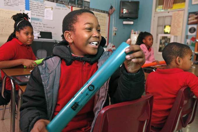 In this Dec. 16, 2018 photograph, fourth grader Jimmarious Frazier laughs at one of his classmates' inspired blues song at Tunica Elementary School in Tunica, Miss. (AP Photo/Rogelio V. Solis)