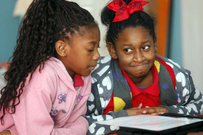 In this Dec. 16, 2018 photograph, fourth graders Precious Reed, right, reacts to the blues lyrics suggested by Heaven Jackson at Tunica Elementary School in Tunica, Miss., as they explore the Delta’s homegrown music, a subtle way of incorporating the Mississippi Blues Trail Curriculum into their lessons of science, math, social studies and English. (AP Photo/Rogelio V. Solis)