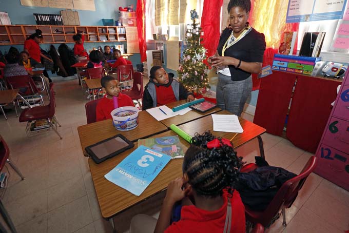 In this Dec. 16, 2013 photograph, Chevonne Dixon, a fourth grade teacher at Tunica Elementary School in Tunica, Miss., speaks to the students about the elements of their blues song in class. Dixon leads her students into exploring the Delta’s homegrown music, a subtle way to apply this new Mississippi Blues Trail Curriculum into lessons for science, math, social studies and English. (AP Photo/Rogelio V. Solis)