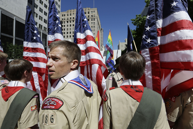 In this June 30, 2013 file photo, Boy Scouts from the Chief Seattle Council carry U.S. flags as they prepare to march in the Gay Pride Parade in downtown Seattle. The Boy Scouts of America, in the most contentious change of membership policy in a 103-year history, will accept openly gay youths in Scout units starting on New Year's Day 2014. (AP Photo/Elaine Thompson, File)