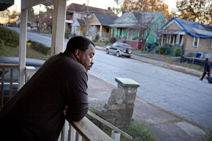 Willie Andrews stands on the front porch of his home in the Mechanicsville neighborhood surrounding the Atlanta Braves stadium, Wednesday, Nov. 20, 2013, in Atlanta. (AP Photo/David Goldman)