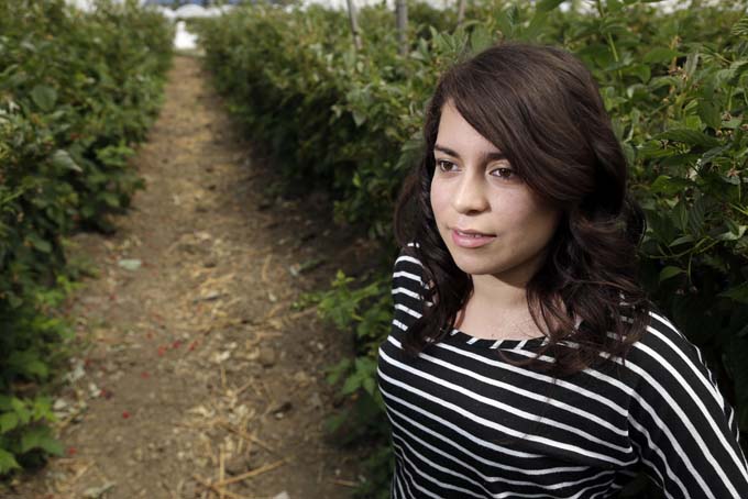 In this Wednesday, Aug. 7, 2013 photo, Dulce Sixtos, 16, poses for a portrait in a farm field in Watsonville, Calif. Sixtos, whose father is a fieldworker, hopes to attend college and study law. A(AP Photo/Marcio Jose Sanchez)