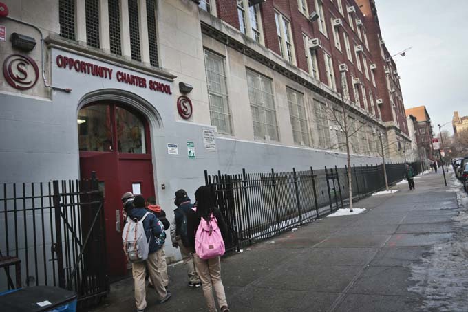  In this Dec. 20, 2013 photo, students use the entrance for Success Academy and Opportunity Charity schools, both of which share space inside Harlem's P.S. 241, in New York. (AP Photo/Bebeto Matthews)