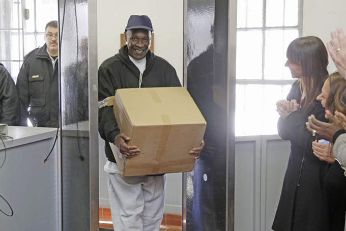 Stanley Wrice, center, convicted of rape and sentenced to 100 years in prison in 1982, smiles as he leaves Pontiac Correctional Center Wednesday, Dec. 11, 2013 in Pontiac, Ill. Wrice was released after serving more than 30 years in prison when a Cook County Judge overturned his conviction the day before and granted him a new trial. Wrice has claimed for decades he was beaten and coerced into confessing to the rape by Chicago police Area 2 detectives working for disgraced former Chicago police Lt. Jon Burge. Burge himself, is now in federal prison after being convicted of perjury related to torture allegations. Judge Richard Walsh's ruling comes after the officers working for Lt. Burge, who Wrice says beat him, invoked their right not to testify. (AP Photos/M. Spencer Green)