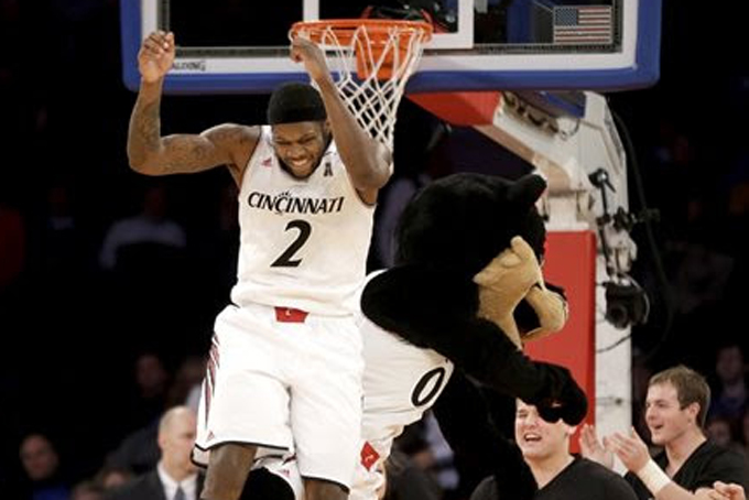 Cincinnati's Titus Rubles celebrates with the team mascot after an NCAA college basketball game against Pittsburgh in New York, Tuesday, Dec. 17, 2013. Rubles sank the final shot to put Pittsburgh ahead 44-43. (AP Photo/Seth Wenig)