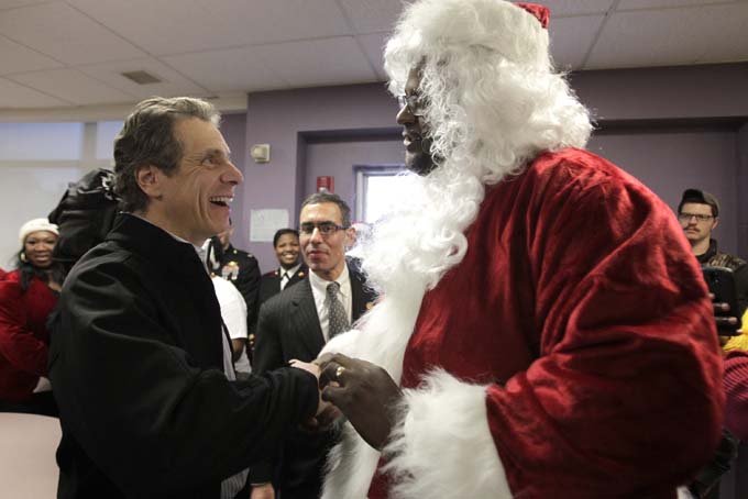 New York Gov. Andrew Cuomo greets bus driver Darnell Barton, dressed as Santa, at the Lydia T. Wright School of Excellence in Buffalo, N.Y. on Saturday, Dec. 21, 2013. Barton was hailed as a hero in October when he talked a distraught woman off of a highway overpass on the Scajaquada Expressway. (AP Photo/Buffalo News, Harry Scull Jr.)