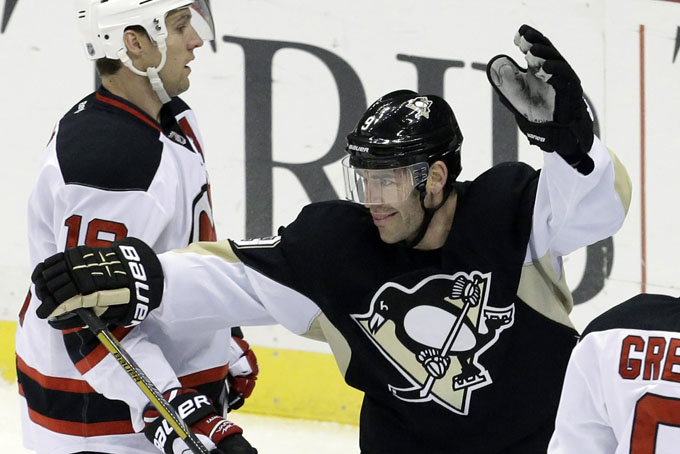 Pittsburgh Penguins' Pascal Dupuis (9) skates past New Jersey Devils' Travis Zajac, left, as he begins to celebrate his first-period goal during an NHL hockey game in Pittsburgh Friday, Dec. 13, 2013.(AP Photo/Gene J. Puskar)