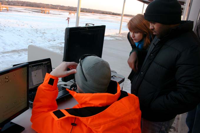 In this photo provided by Jamey Jacob, John Sievert, left, Emily Rogers, center, and Libin Daniel, engineering students at Oklahoma State University, track an unmanned aerial vehicle on Wednesday, Dec. 11, 2013, at OSU’s unmanned aircraft flight station in Stillwater, Okla. With an established graduate program at OSU and a competitive bid with about two dozen other states to become a federally designated testing facility for drones, Oklahoma is positioning itself to become a hotbed for this booming sector of the aerospace industry. (AP Photo/ Oklahoma State University, Jamey Jacob)