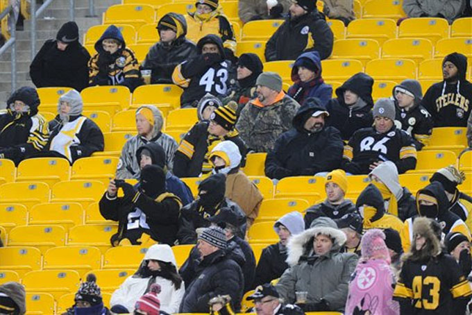 Football fans watch the NFL football game between the Pittsburgh Steelers and the Cincinnati Bengals on Sunday, Dec. 15, 2013, in Pittsburgh. (AP Photo/Don Wright)
