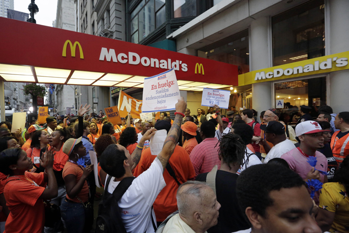 In this Thursday, Aug. 29, 2013, file photo, protesting fast food workers demonstrate outside a McDonald's restaurant on New York's Fifth Avenue, in New York. (AP Photo/Richard Drew, File)