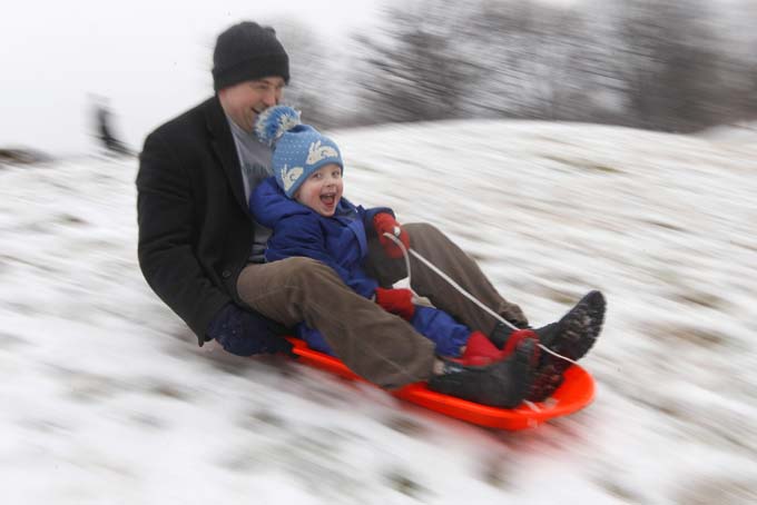 In this Saturday, Jan. 21, 2012, file photo, Matt Redmond, 3, and his father, Mike, ride a sled down a hill after an overnight snowfall in Baltimore. (AP Photo/Patrick Semansky, File)