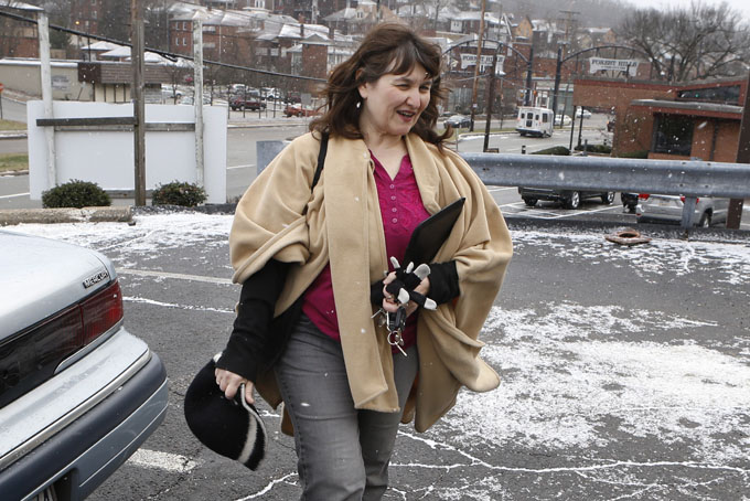 Shelagh Collins walks from her car to a job search appointment on Dec. 30, in Forest Hills, Pa., an eastern suburb of Pittsburgh. Collins gets by on occasional secretarial temp work and unemployment compensation checks, but she can’t afford specialized treatment for her various health conditions that limit her ability to do certain jobs. (AP Photo/Keith Srakocic)