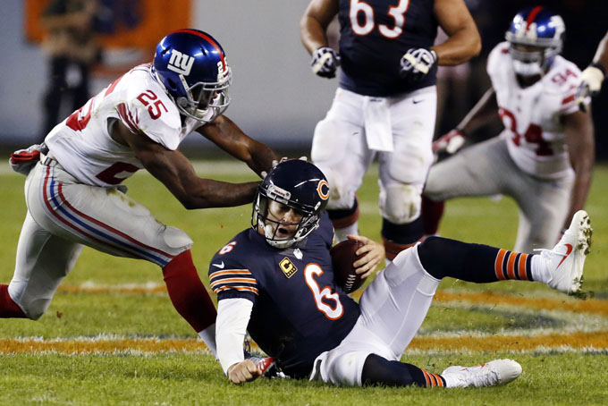 In this Oct. 10, 2013, file photo, New York Giants safety Antrel Rolle (26) pushes on the helmet of Chicago Bears quarterback Jay Cutler (6) during the second half of an NFL football game in Chicago. Rolle was penalized 15-yards for unnecessary roughness on the play. (AP Photo/Charles Rex Arbogast, File)