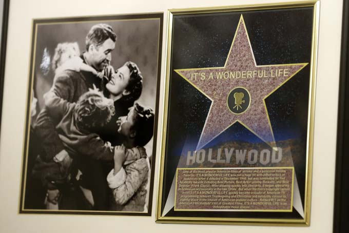 In this photo made on Friday, Dec. 20, 2013, a framed plaque with a photograph of a scene from the 1946 film "It's A Wonderful Life" starring Jimmy Stewart, left, and a Hollywood star are on display at the Jimmy Stewart Museum in Indiana, Pa. (AP Photo/Keith Srakocic)