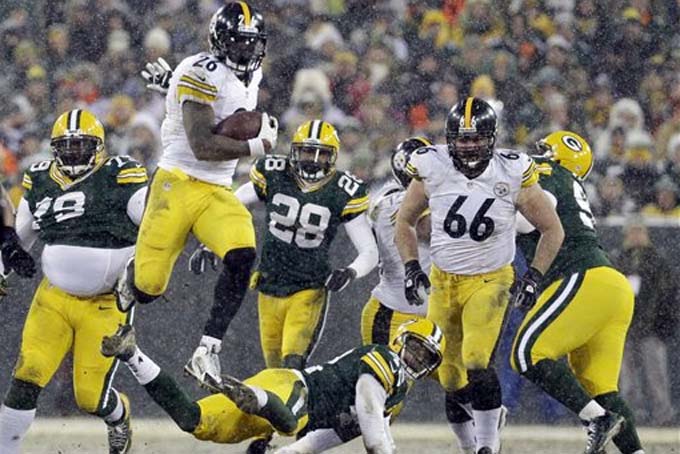 Pittsburgh Steelers' Le'Veon Bell (26) leaps over Green Bay Packers' Morgan Burnett during the second half of an NFL football game Sunday, Dec. 22, 2013, in Green Bay, Wis. (AP Photo/Mike Roemer)
