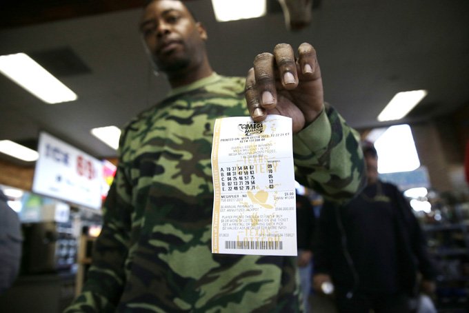  John Hollis shows off his Mega Millions lottery ticket he purchased at the Fuel City convenience story Monday, Dec. 16, 2013, in Dallas. (AP Photo/LM Otero)