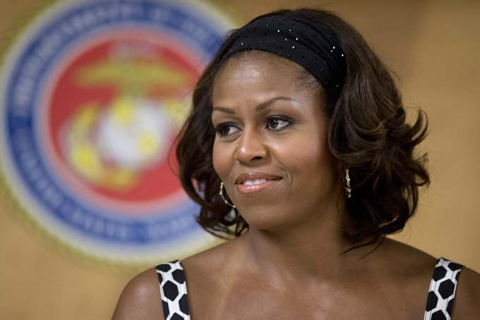 First lady Michelle Obama looks out from the stage as President Barack Obama speaks to members of the military and their families in Anderson Hall at Marine Corps Base Hawaii, Wednesday, Dec. 25, 2013, in Kaneohe Bay, Hawaii. The first family is in Hawaii for their annual holiday vacation. (AP Photo/Carolyn Kaster)