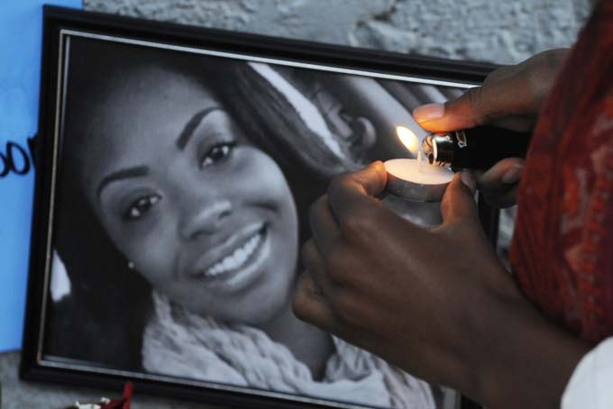 A candle is lighted for shooting victim Kimberle Johnson Sunday Dec. 29, 2013, during a candlelight vigil for victims of a fatal shooting at Centennial Hill Bar and Grill in Montgomery, Ala. (AP Photo/Montgomery Advertiser, Mickey Welsh)