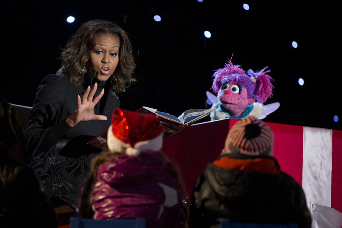 First lady Michelle Obama reads “Twas The Night Before Christmas” with muppet Abby Cadabby to children on stage during the 2013 National Christmas Tree Lighting ceremony at the Ellipse near teh White House in Washington, Friday, Dec. 6, 2013. (AP Photo/Carolyn Kaster)