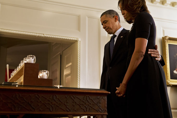 President Barack Obama and first lady Michelle Obama take a moment of silence in honor of the Newtown shooting victims on the one year anniversary of the tragedy, in the Map Room of the White House in Washington, Saturday, Dec. 14, 2013. (AP Photo/Jacquelyn Martin)