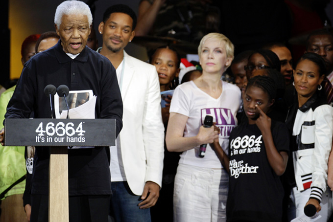 This June 27, 2008 file photo shows Nelson Mandela, left, speaking as Will Smith, second from left, Annie Lennox, center, and Jada Pinket Smith, right, look on at the 46664 charity concert in honor of Mandela's upcoming 90th birthday in London. Heroic in his deeds, graceful in his manner, sainted in his image, Nelson Mandela long served as both cause and muse in the entertainment community. From the 1960s, when he was a political prisoner and South Africa was under the laws of apartheid, right up to recent times, when the racist laws of the land had fallen and he was among the world’s most admired people, Mandela inspired concerts, songs, poems, fiction and movies. (AP Photo/Edmond Terakopian, file)