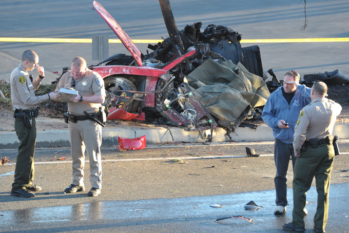 Sheriff's deputies work near the wreckage of a Porsche that crashed into a light pole on Hercules Street near Kelly Johnson Parkway in Valencia, Calif., on Saturday, Nov. 30, 2013. (AP Photo/The Santa Clarita Valley Signal, Dan Watson)