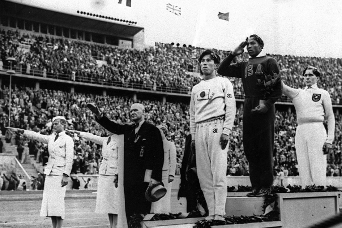  In this Aug. 11, 1936 file photo, Olympic broad jump medalists salute during the medals ceremony at the Summer Olympics in Berlin. From left on podium are: bronze medalist Jajima of Japan, gold medalist Jesse Owens of the United States and silver medalist Lutz Long of Germany. (AP Photo/File)