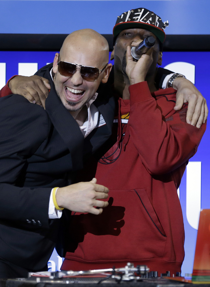 A Pitbull impersonator, left, hugs DJ Irie, right, during an NBA basketball game between the Miami Heat and Indiana Pacers, Wednesday, Dec. 18, 2013, in Miami. (AP Photo/Lynne Sladky)