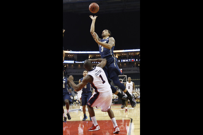 Pittsburgh's Cameron Wright (3) shoots over Duquesne's Derrick Colter (1) in the first half of an NCAA college basketball game on Saturday, Nov. 30, 2013, in Pittsburgh. (AP Photo/Keith Srakocic)