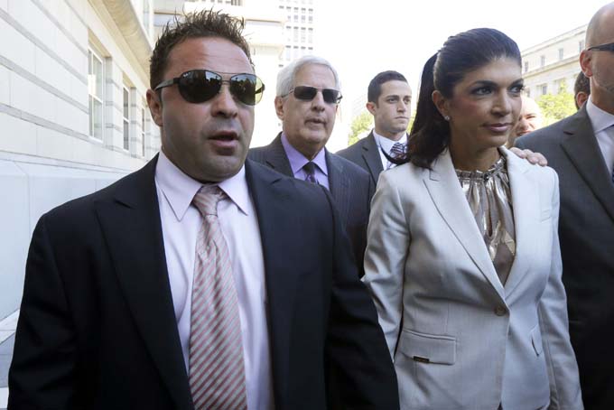 In this July 30, 2013 file photo, "The Real Housewives of New Jersey" stars Giuseppe "Joe" Giudice, 43, left, and his wife, Teresa Giudice, 41, of Montville Township, N.J., walk out of Martin Luther King, Jr. Courthouse after an appearance in Newark, N.J. (AP Photo/Julio Cortez, File)