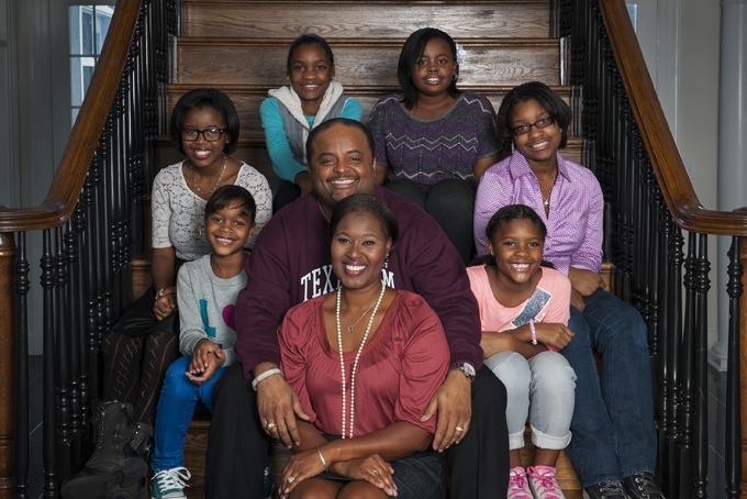 In this Nov. 6, 2013 photo, former CNN political analyst Roland Martin, along with his wife, Jacquie Hood Martin, front center, pose with the six girls they are raising in the home they moved into in June, in Leesburg, Va. The girls, clockwise from left, are Raquel, 9, Alantis, 16, Chelsea, 13, Anastasia, 13, MyKayla, 14 and Rachel, 9. The twins are Jacquie's, and the other girls are Roland's nieces. (AP Photo/The Washington Post, Katherine Frey)