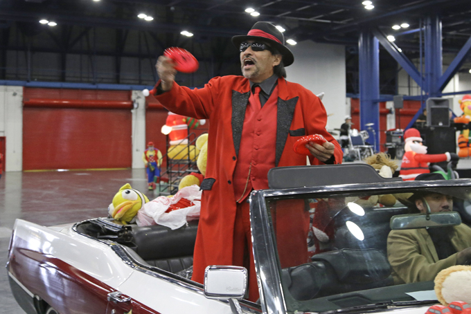 Pancho Claus throws presents as he arrives at a charity holiday event in a low-rider Saturday, Dec. 14, 2013, in Houston. The Tex-Mex Santa grew out of the Chicano civil rights movement in the late 1970s and early 1980s and is sometimes referred to as Santa Claus’ cousin from the South Pole. (AP Photo/Pat Sullivan)