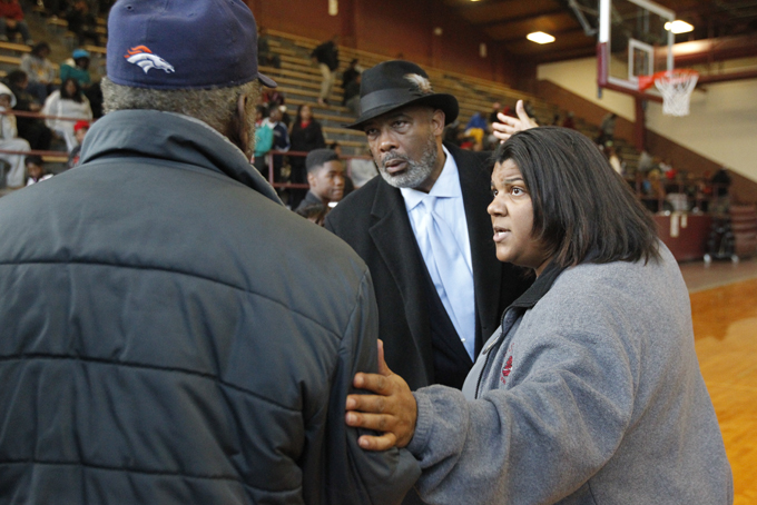 Toledo school board member Larry Sykes, left, and school principal Treva Jeffries, right, speaks with a parent inside the gym of Scott High School after a standoff in Toledo, Ohio, Dec. 2. (AP Photo/The Blade, Amy E. Voigt) 