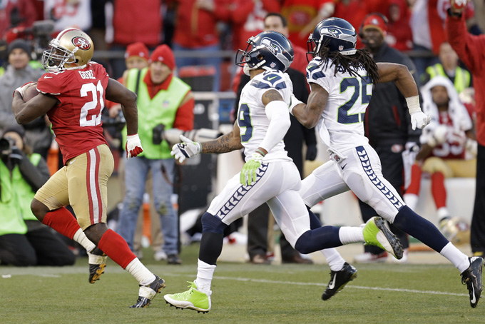 San Francisco 49ers running back Frank Gore, left, carries the ball on a 51-yard run as Seattle Seahawks free safety Earl Thomas (29) and cornerback Richard Sherman (25) look on in the fourth quarter of an NFL football game, Sunday, Dec. 8, 2013, in San Francisco. The 49ers defeated the Seahawks 19-17. (AP Photo/Ben Margot)