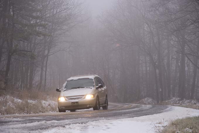 A car travels on Snake Road in Conyngham Township, Pa., on Tuesday, Nov. 26, 2013, as a mixture of rain, freezing rain and sleet fall heavily throughout the area. (AP Photo/The News-Item, Larry Deklinski)