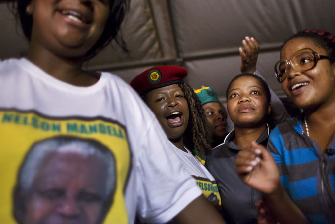 Youth members of the African National Congress (ANC) dance, pray and sing songs honoring Nelson Mandela at a nighttime vigil at the Walter Sisulu University in Mthatha, South Africa, Saturday, Dec. 14, 2013. ANC members, party leaders, and government officials gathered for the traditional night vigil to honor Mandela on the eve of his burial. (AP Photo/Ben Curtis)