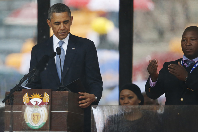 President Barack Obama looks down as he stands next to the sign language interpreter as he makes his speech at the memorial service for former South African president Nelson Mandela at the FNB Stadium in Soweto near Johannesburg, Tuesday, Dec. 10, 2013. (AP Photo/Matt Dunham)