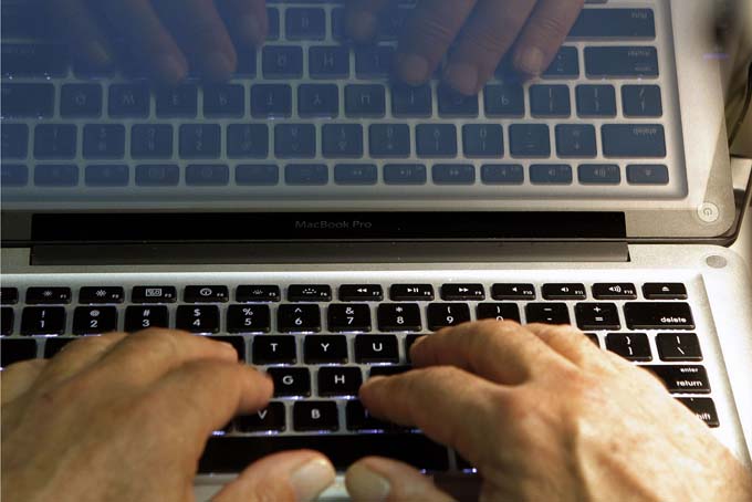 In this photo illustration, hands type on a computer keyboard in Los Angeles. (AP Photo/Damian Dovarganes, File)