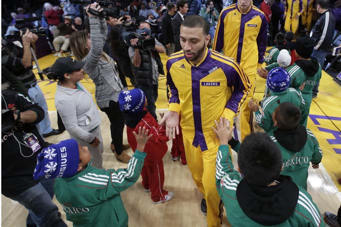 Members of Triqui kids basketball team, made up of children from the mountainous region of Oaxaca, Mexico, greet the Los Angeles Lakers before an NBA basketball game against the Minnesota Timberwolves in Los Angeles, Friday, Dec. 20, 2013. (AP Photo/Chris Carlson)   