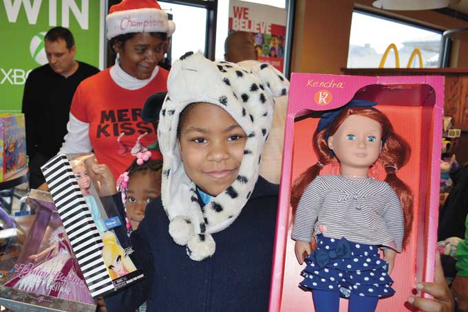 A TOY FOR ME—Kids enjoy their toys given to them by Champion Enterprises at the 37th annual “Toys For Champions Christmas Party and Toy Giveaway.” (Photo by Debbie Norrell)