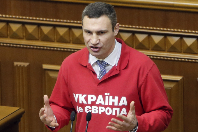 In this Thursday, Nov. 21, 2013 file photo Ukrainian lawmaker and chairman of the opposition party Udar (Punch), WBC heavyweight boxing champion Vitali Klitschko speaks during the parliament session in Kiev, Ukraine. Slogan on jersey reads "Ukraine is Europe". (AP Photo/Efrem Lukatsky, File)