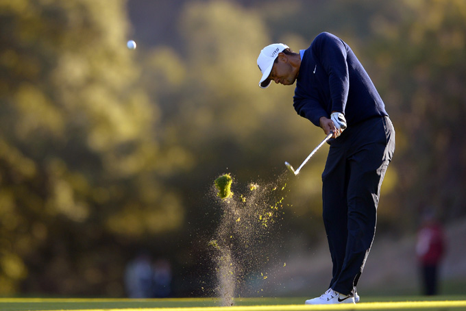 Tiger Woods makes his approach shot on the 18th hole during the first round of the Northwestern Mutual World Challenge golf tournament at Sherwood Country Club, Thursday, Dec. 5, 2013, in Thousand Oaks, Calif. (AP Photo/Mark J. Terrill)